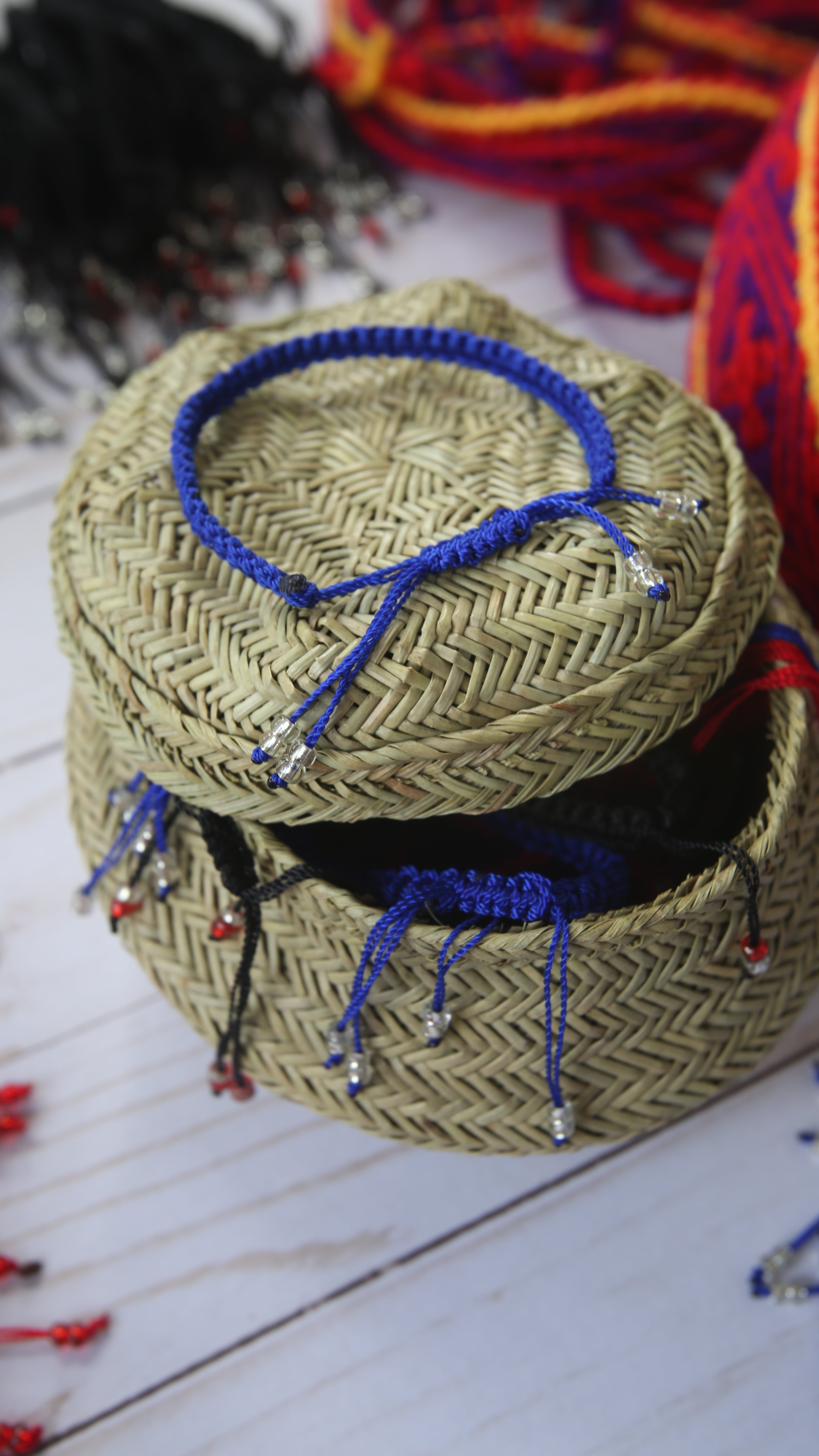 Basket with several blue handcrafted bracelets on it.